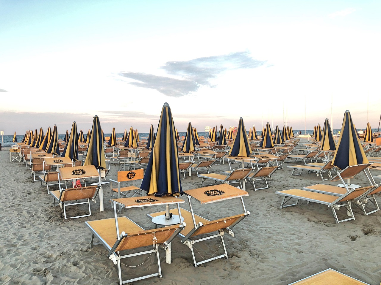 Vista panoramica di Rimini con turisti e spiagge affollate durante la stagione estiva.