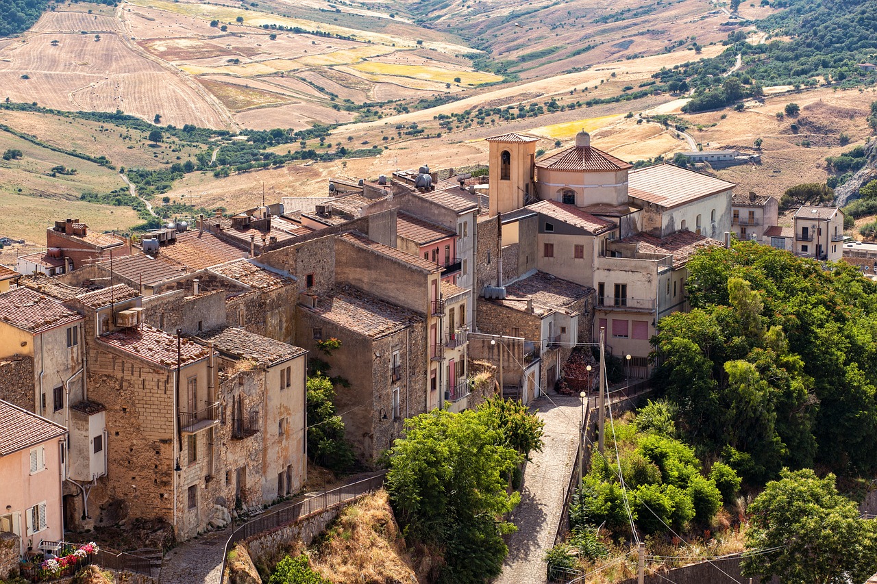 Panorama del borgo siciliano con piatti tipici serviti in un ristorante locale.