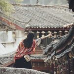 Turista deluso in una località affollata e costosa, con cartelli di divieto e prezzi elevati.