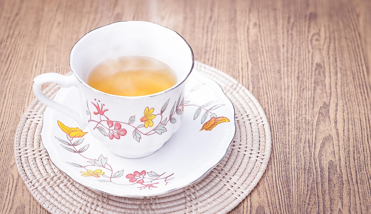 Tisana serale fumante in una tazza, circondata da erbe fresche e ingredienti naturali per la digestione.