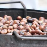 Tavola imbandita con piatti a base di tartufo e castagne durante una sagra di dicembre.