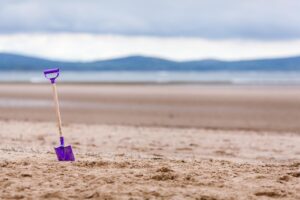 Spiaggia di sabbia dorata in Irlanda del Nord, con onde che si infrangono e cielo azzurro.