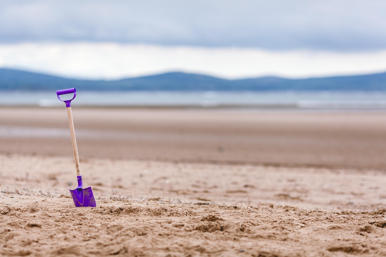 Spiaggia di sabbia dorata in Irlanda del Nord, con onde che si infrangono e cielo azzurro.