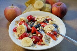 Colazione sana con yogurt e frutta fresca in una ciotola, simbolo di un'alimentazione leggera e bilanciata.