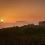 Panorama mozzafiato di un paese sardo, con case colorate e mare cristallino, simile a un set cinematografico.