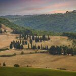 Panorama mozzafiato della campagna toscana, con dolci colline e cipressi.