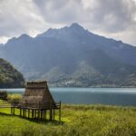 Vista panoramica del lago sottovalutato in Italia, circondato da montagne e vegetazione, simile a un fiordo.