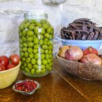 Olive grandi e succose su un ramo, illustrate nel contesto di un trucco per una migliore coltivazione.