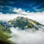 Borgo di Andria con case storiche e un mercato di burrate fresche in primo piano.