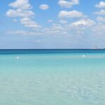 Spiaggia del Salento con sabbia bianca e mare cristallino, ideale per una giornata di sole.