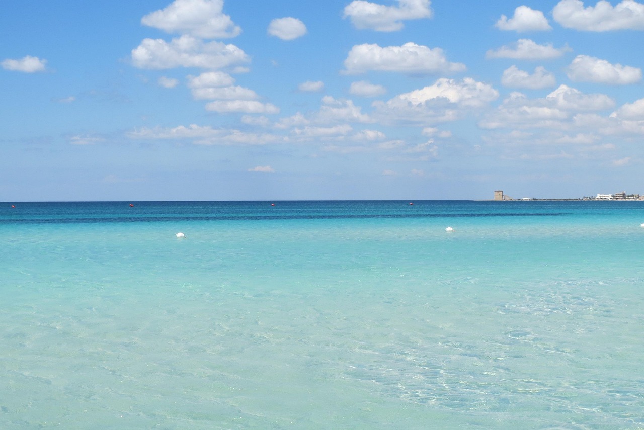 Spiaggia del Salento con sabbia bianca e mare cristallino, ideale per una giornata di sole.