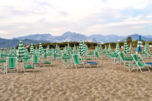 Spiaggia italiana premiata con acque cristalline e sabbia fine, vista panoramica di bagnanti e ombrelloni.
