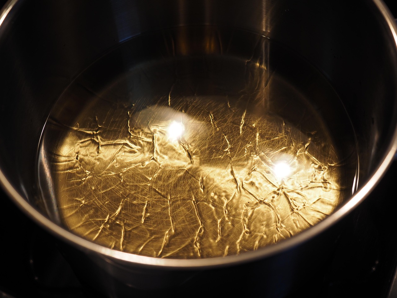 Olio in padella con ingredienti freschi pronti per essere aggiunti.