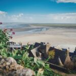 Spiaggia di sabbia fine con acque turchesi e scogliere a picco, simbolo della bellezza costiera francese.