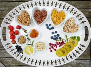 Piatto di cibi salutari per abbassare il colesterolo, tra cui frutta, verdura e cereali integrali.