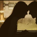 Due cuori intrecciati con simboli zodiacali sullo sfondo, rappresentando l'amore e la dipendenza emotiva.