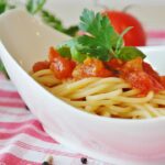 Pasta al pomodoro servita in un piatto, con ingredienti freschi e un occhio alla salute e glicemia.