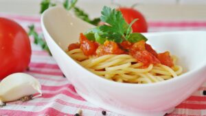 Pasta al pomodoro servita in un piatto, con ingredienti freschi e un occhio alla salute e glicemia.