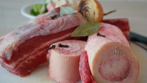 Brodo di carne fatto in casa in una pentola, con ingredienti freschi e aromatici visibili.